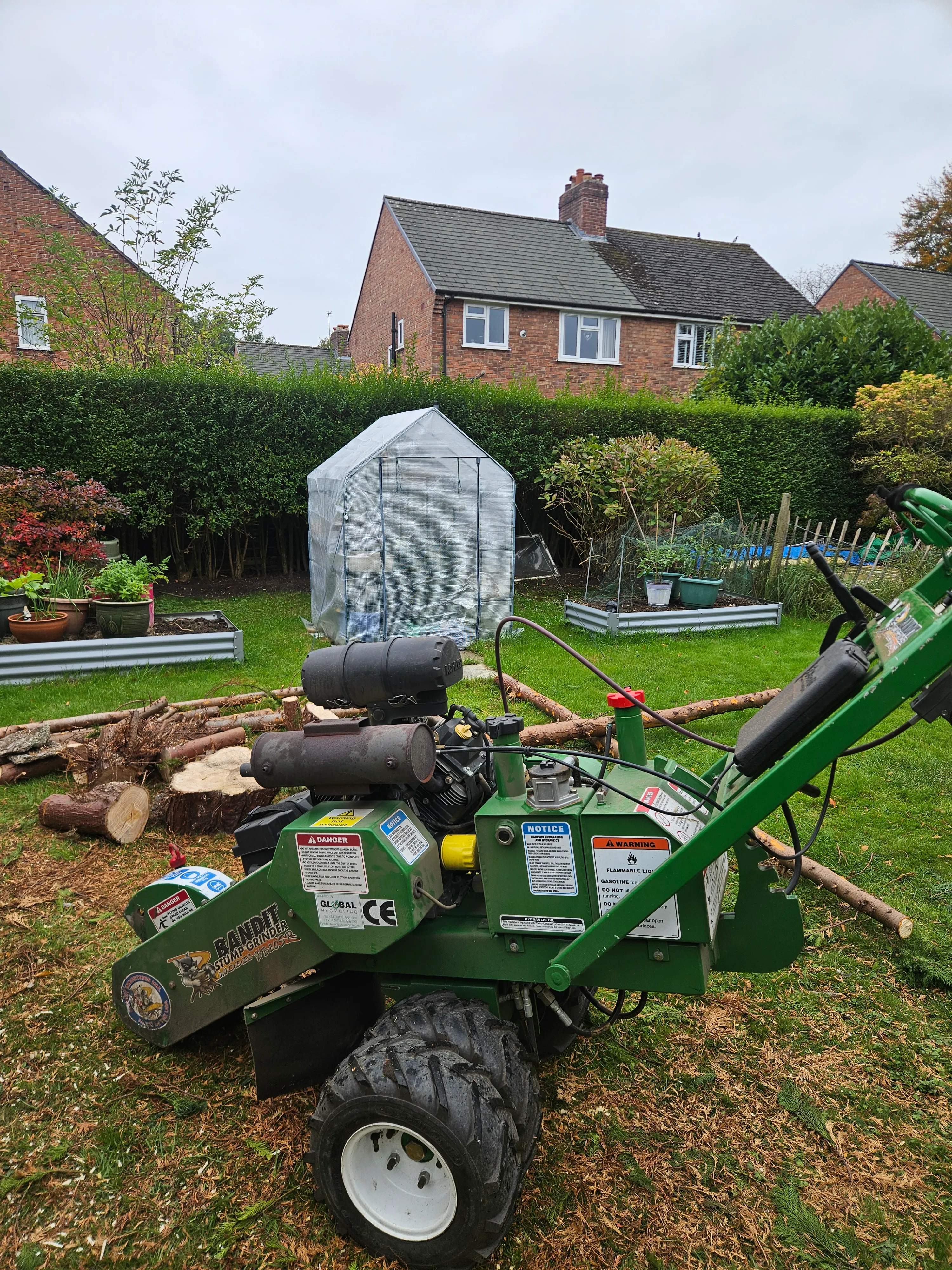 A green lawn mower sitting on top of a lush green field.