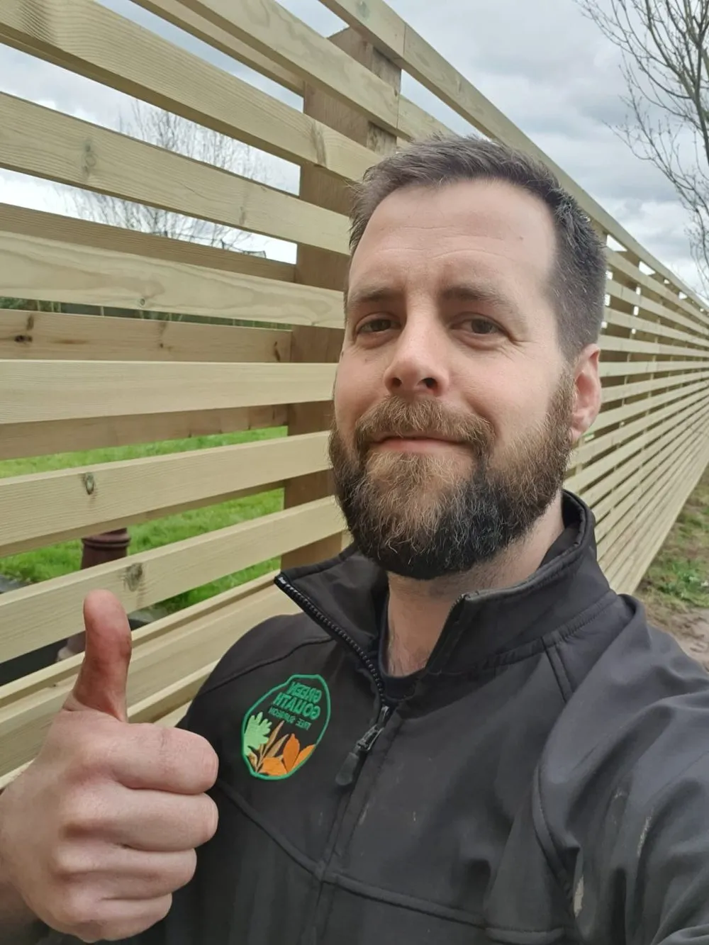 A man with a beard giving a thumbs up.